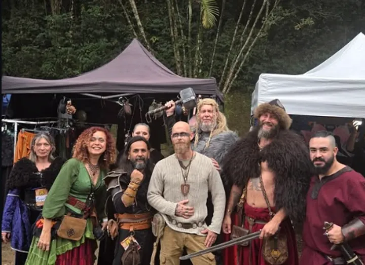 Grupo reunido em frente às tendas de um encontro de cultura medieval